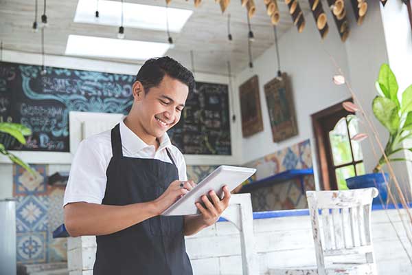 Worker using a tablet in a cafe