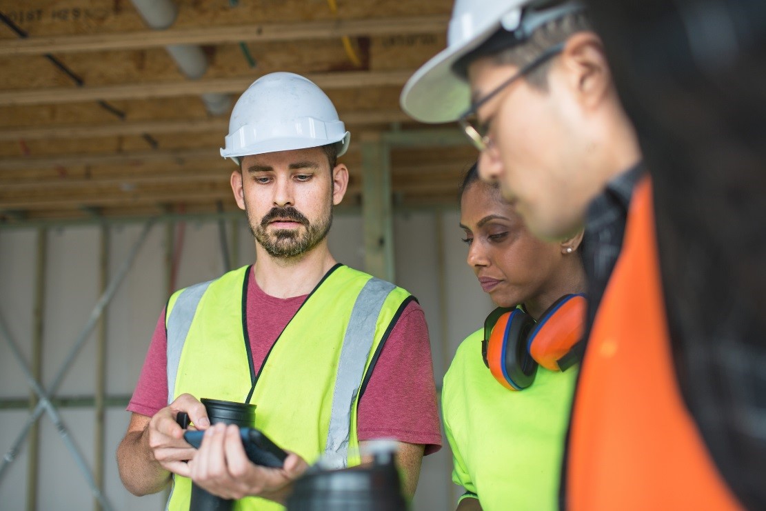 Workmen viewing a tablet device