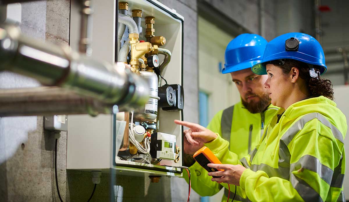 Workers viewing electrical panel