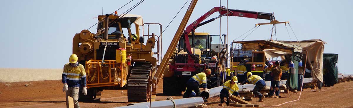 Men and machinery working on a pipeline