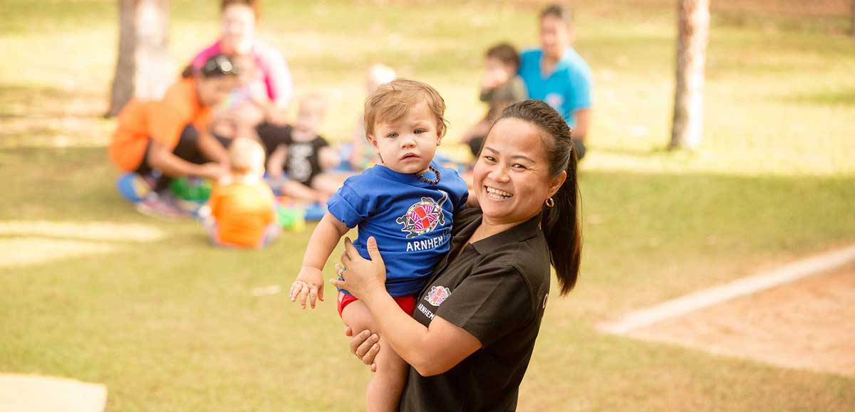 Woman holding young child in park