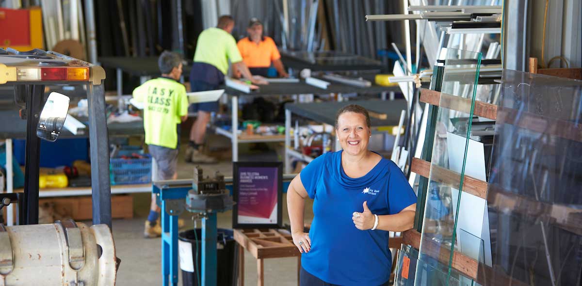 Mary Linnell of Easy Glass Services standing in workshops