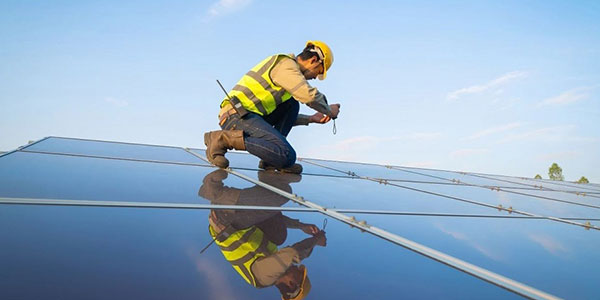 Person working on solar panels rooftop