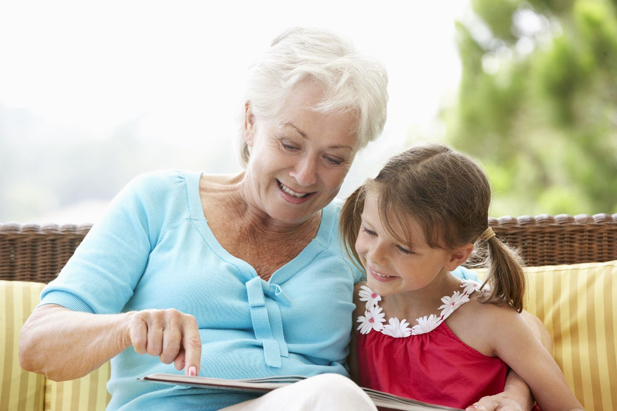 Elderly woman and granddaughter reading a book