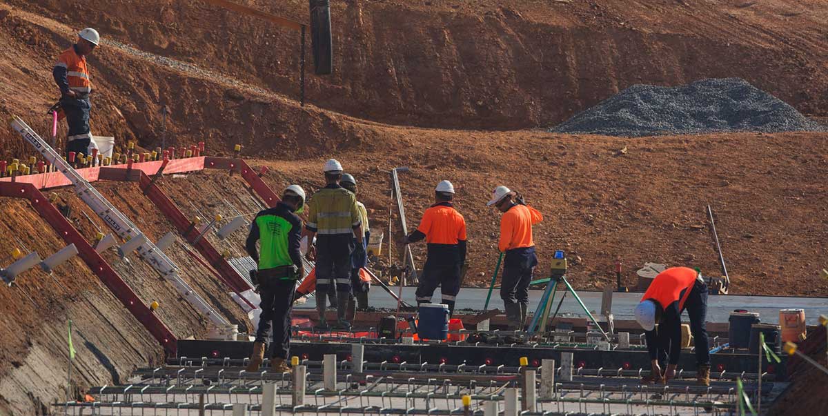 Workmen constructing a concrete pad